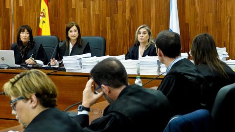 El procedimiento, apilado en columnas. Dos de las tres magistradas del tribunal que juzga la causa del Karar siguen la vista con una copia impresa del procedimiento ordenado en columnas sobre la mesa del estrado donde se sientan. Las defensas estn a su izquierda; y la Fiscala, a la derecha. 