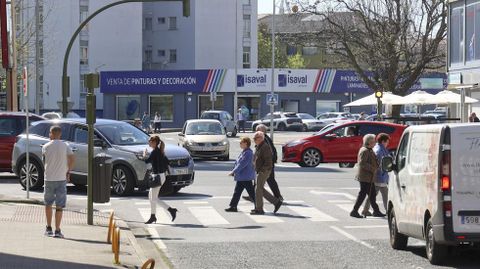 Trfico de vehculos y peatones cruzando en un cruce de la avenida de Esteiro.