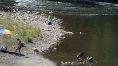 Unos ba�istas en una de las playas que forma en Las Caldas (Asturias) el r�o Nal�n
