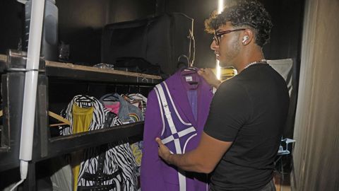 Kenneth ense�a el espacio del escenario en el que guardan el vestuario de los cantantes masculinos.