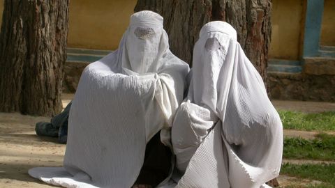 Dos mujeres vestidas con burka esperan en la calle para ser atendidas en un hospital en Afganist�n.