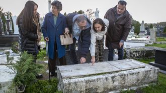 Juana Bouzas (con abrigo azul) junto a otros vecinos de De�n ante la tumba de Carmen.
