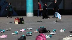Ciudadanos de Teher�n miran los zapatos que han dejado en protesta los estudiantes tras el ataque a�reo de EE UU, en abril del 2025, que acab� con la vida de cientos de j�venes