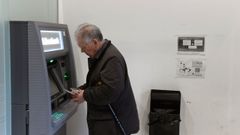 Un hombre de avanzada edad, saca dinero de un calero autom�tico de una entidad bancaria en el centro de Oviedo
