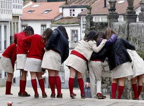 Un grupo de ni�as con uniforme escolar se hacen una foto en las escaleras de Raxoi, en Santiago. 