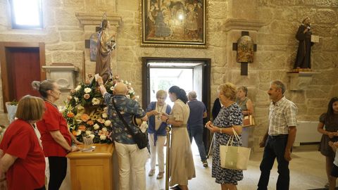 Los fieles pasan estampas por la imagen de Santa Marta