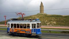 El antiguo tranv�a tur�stico coru��s pasando por delante de la Torre de H�rcules en su ruta por el paseo mar�timo.