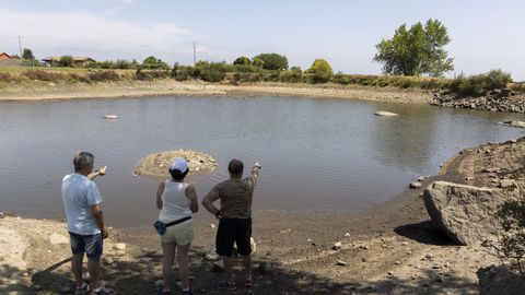 Vecinos de Cerceda muestran el lago desde donde captan el agua de la tra�da, casi seco.