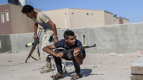 Los combatientes del Gobierno de Serraj  se cubren del fuego enemigo en la l�nea del frente de A Khalla