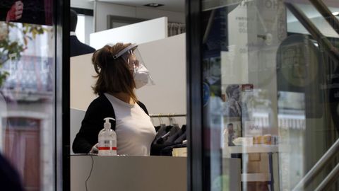 La dependencia de un comercio, con pantalla facial y mascarilla, en una foto de mayo del a�o pasado
