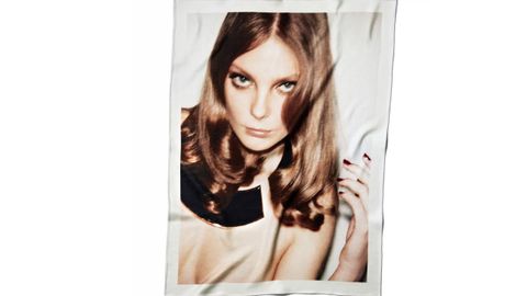 Ezra Petronio x Zara 50 Aniversario. Manta estampada. Una manta de mezcla de lana y cachemira estampada con una fotografía de Enik? Mihalik tomada por Ezra Petronio. Su imagen se reproduce a toda superficie de una de las caras de la manta, convirtiendo un retrato de estudio en una pieza textil. La tela combina la calidez y estructura de la lana con la suavidad de la cachemira, ofreciendo una sensación de alta calidad al tacto. Diseñada tanto como objeto funcional como declaración visual para el hogar