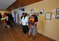 Turistas y peregrinos observan una muestra en el faro.