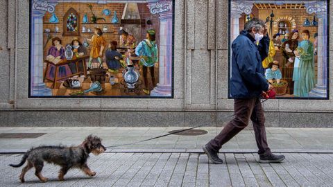 Un hombre pasea con su perro por el centro de Gijn