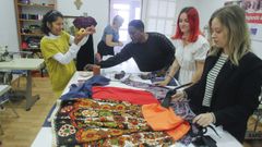 A la derecha, Lara y Noa, estudiantes del grado de Moda junto con las mujeres del taller de costura de C�ritas