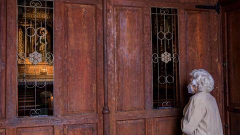  Una mujer reza en el exterior de la capilla de la Balesquida, en la plaza de la Catedral de Oviedo