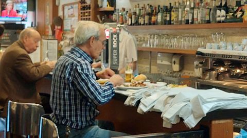 Dos personas comen en la barra de una taberna tradicional en Oporto.