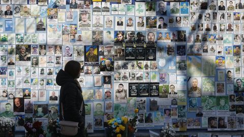 Una mujer frente a un memorial de soldados cados durante la guerra en Ucrania en Kiev.