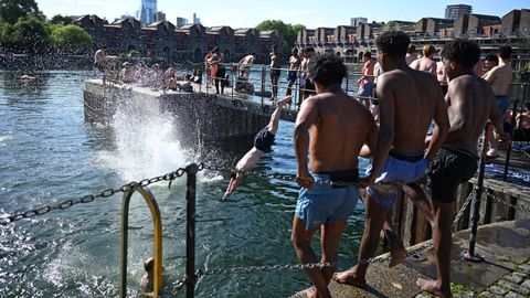 Varias personas se refrescan en el r�o T�mesis de Londres (Reino Unido).