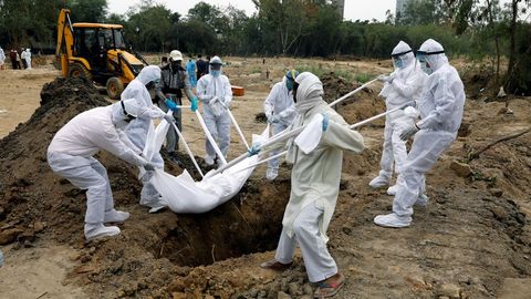 En Nueva Dehli, los sepultureros visten trajes protectores para enterrar a los fallecidos por coronavirus