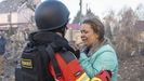 Un bombero consuela a una mujer cuya casa sufri el ataque de los cohetes rusos cerca de Odesa.