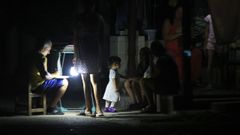 ersonas esperan durante un apag�n este jueves, en La Habana (Cuba). La estatal Uni�n El�ctrica (UNE) de Cuba prev� de nuevo este viernes prolongados apagones en toda la isla y estima que el mayor corte del suministro, en el momento de mayor demanda, dejar� sin servicio el�ctrico a la vez al 51 % del pa�s.