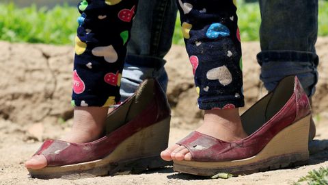 En Lbano, una nia refugiada de la guerra de Siria viste unos zapatos de adulto. All, al drama del da a da han sumado el coronavirus