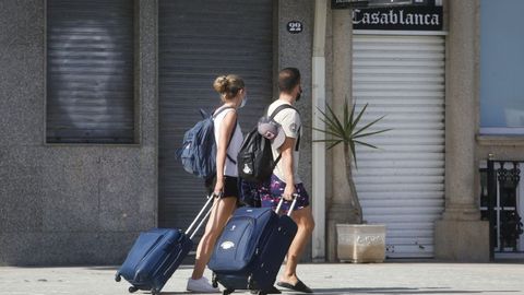 Turistas con maletas en O Grove, en una imagen de archivo.