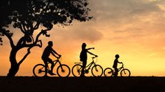 Una familia en bicicleta viendo un atardecer