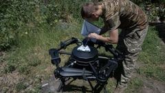 Un soldado ucraniano carga un dron con combustible.