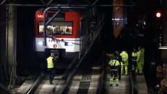 Varios operarios junto al tren de Cercan�as que ha descarrilado este martes pasadas las dos y media de la tarde en la entrada de la madrile�a estaci�n de Atocha, lo que ha interrumpido el servicio entre dicha estaci�n y Recoletos, en un momento de fuerte afluencia por el puente de la Constituci�n.