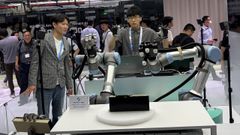 Un hombre maneja unos brazos rob�ticos a distancia en uno de los pabellones de Computex 2026, en Taip�i.