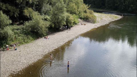 Varios jóvenes se bañan en el río Nalón, en las proximidades de Las Caldas