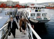 Viajeros de la lnea Moaa-Vigo al llegar al puerto, con uno de los barcos de Nabia al fondo.