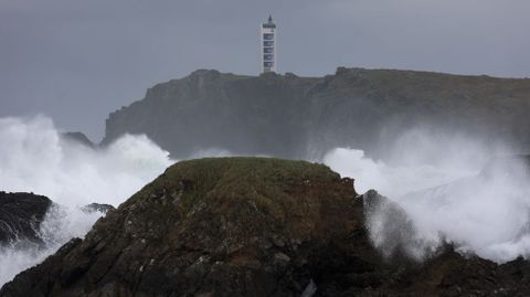 El faro de Punta Frouxeira entre el oleaje que azota la costa de Meir�s.