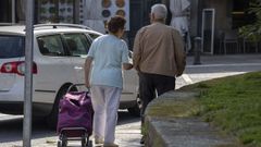 Dos personas de la tercera edad caminando por Santiago.