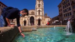 Un hombre se refresca del calor en Oviedo