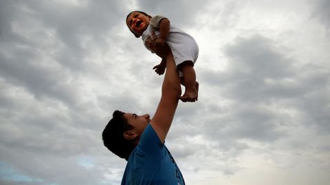 Un oasis de alegr�a. A la izquierda, un ni�o es levantado en brazos por su hermano mayor en un campo en la frontera de Hungr�a y Austria durante uno de esos momentos de alegr�a que se crean para enga�ar a los m�s peque�os e intentar hacerles llevar lo mejor posible esta dura traves�a. 