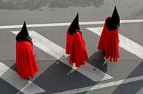 Tres penitentes participantes en las celebraciones de la Semana Santa en la ciudad.