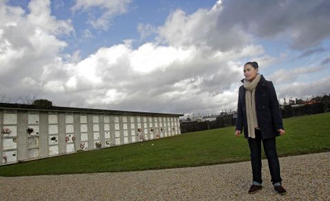 La concejala del PP de Bergondo Silvia V�zquez, en el cementerio parroquial, construido en suelo de uso agrario, tal como se recoge en la ficha sobreimpresionada en la foto. 