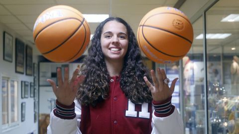 Elena Rodr�guez con su beisbolera de Harvard en la sala de trofeos del Baxi Ferrol. 
