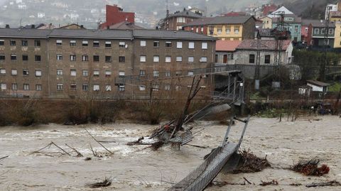 Aspecto que presenta una pasarela peatonal sobre el ro Aller a causa del temporal de lluvias registrado en los ltimos das en Asturias