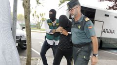 Uno de los detenidos es conducido por la Guardia Civil a las dependencias judiciales