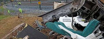 Restos del tren siniestrado, el primer d�a despu�s de abrirse el cord�n policial. Al fondo, t�cnicos del ADIF trabajando en la v�a en la que ocurri� el accidente.