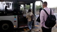 Varios j�venes entrando al autob�s en la parada frente a la comisar�a de la Polic�a Local de Oleiros.
