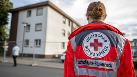 Un trabajador de la Cruz Roja frende al edificio en cuarentena