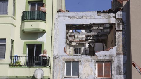 Liliana y Sonia, junto al edificio en ruinas que causa problemas en sus viviendas, en Neda.