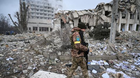 Un soldado ucraniano camina entre edificios destrozados por los bombardeos rusos