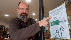 Miguel P�rez muestra el horario de apertura de su taller de reparaci�n de calzado