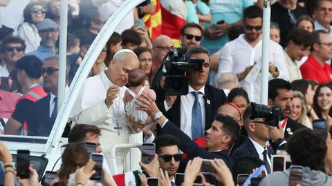 El papa bendice a un beb� durante su recorrido en papam�vil por el estadio.