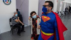 Un hombre vestido de Superman acompa�a a su madre a vacunarse en un centro de salud de Santiago de Chile